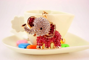 Macro shot of gold elephant keychain featuring vibrant pink crystals and golden metal ring