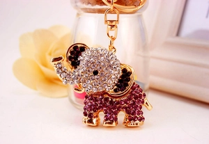 Close-up of golden elephant keychain with sparkling purple and clear rhinestones
