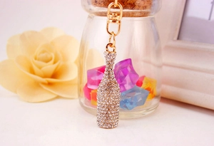Detailed close-up of a crystal-encrusted champagne bottle keychain with gold plating
