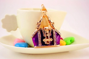 Detail of purple enamel handbag keychain with sparkling rhinestones and golden lobster clasp