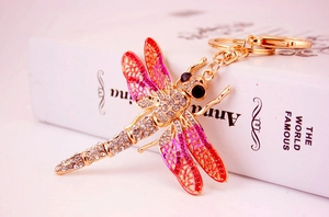 Detail of dragonfly keychain with pink enamel wings and sparkling rhinestones