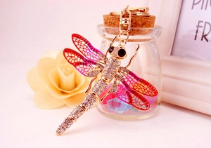 Close-up of golden dragonfly keychain with pink rhinestones and gradient crystal details