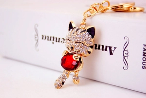Macro view of gold lucky cat keychain featuring red gemstone and crystal rhinestones