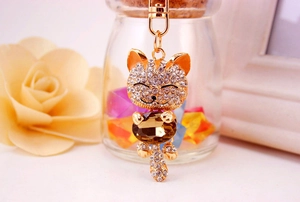 Detail of creative lucky cat keychain with sparkling rhinestones and brown gemstone