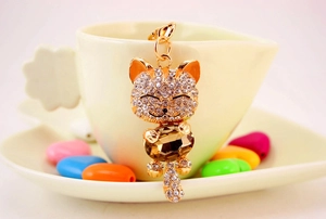 Detail of lucky cat keychain with amber crystal and sparkling rhinestones on gold base