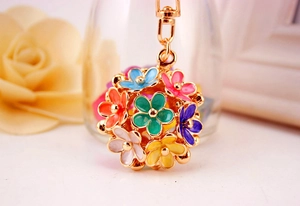 Macro shot of 3D multi-color floral keychain with golden metal base and enamel petals