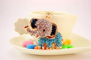 Detailed close-up of a golden elephant keychain decorated with white and blue rhinestones