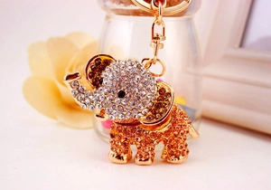 Macro shot of a golden elephant keychain with sparkling clear and amber rhinestones