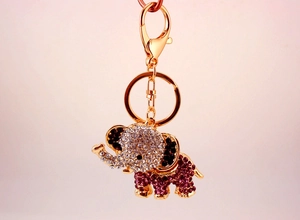 Detailed macro view of gold elephant keychain with sparkling purple and clear rhinestones