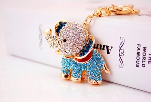Detailed view of a gold-toned elephant keychain with sparkling blue and clear rhinestones