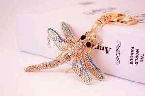 Detail of dragonfly keychain featuring blue and clear rhinestones on gold metal