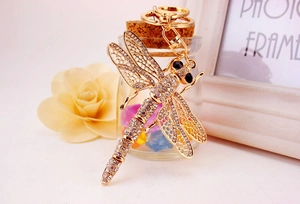 Detail of dragonfly keychain with sparkling crystals and golden metallic finish