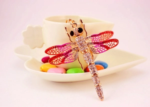 Close-up of colorful dragonfly keychain with pink enamel wings and sparkling rhinestones