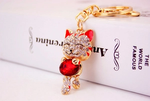 Macro shot of rhinestone lucky cat keychain with red heart gemstone and gold lobster clasp