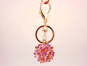Detailed view of 3D purple enamel flower cluster keychain with gold-tone hardware clasp