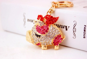 Macro shot of flying pig keychain with sparkling pink rhinestones and golden metal