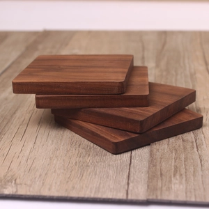 Square black walnut wood coasters set of 4 with natural grain on a matching table