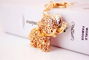 Detail of creative golden elephant keychain with intricate cut-outs and red rhinestones