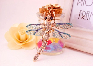 Detail of dragonfly keychain featuring blue enamel wings and clear crystal rhinestones