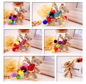 Detail view of gold bear keychains with colorful rhinestones and beaded chains