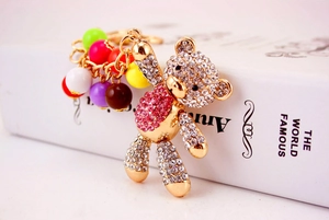 Detail view of gold alloy bear keychain featuring sparkling rhinestones and colorful beads