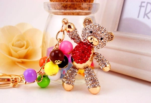 Close-up of golden bear keychain featuring colorful beads and sparkling crystal rhinestones