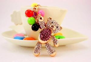Close-up of golden bear keychain with magenta rhinestones and colorful beads decoration