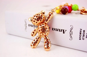 Detailed close-up of golden alloy teddy bear keychain with rhinestones and colorful beads