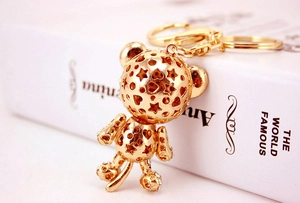 Close-up of golden metal tiger keychain with star and heart cut-outs and rhinestones