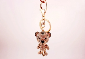 Close-up of golden tiger keychain with sparkling rhinestones and black enamel stripes