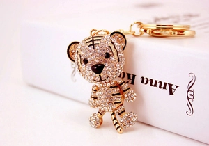 Detailed close-up of a sparkling gold-tone tiger keychain with crystal rhinestones