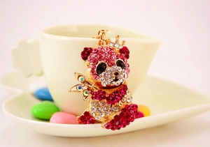 Dettaglio portachiavi panda dorato con strass rosa e bianchi e decorazione con corona