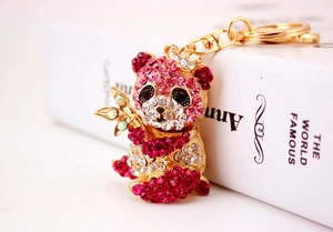 Dettaglio del portachiavi panda dorato con strass rosa e corona luccicante