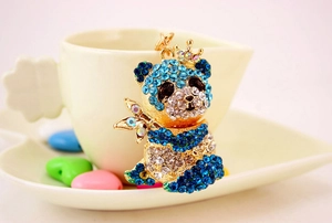 Dettaglio del portachiavi panda con strass scintillanti, corona d'oro e bambù