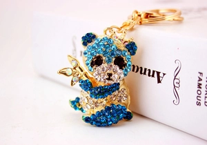 Dettaglio del portachiavi a panda dorato con strass blu e trasparenti scintillanti