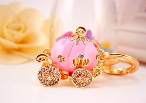 Detailed macro shot of a crystal-studded pink pumpkin carriage keychain for women