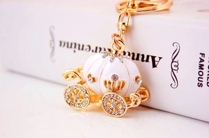 Detail of golden pumpkin carriage keychain with white enamel and sparkling rhinestones