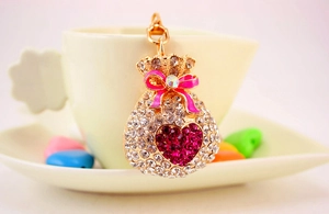 Detail of golden money bag keychain with crystal rhinestones on a coffee cup