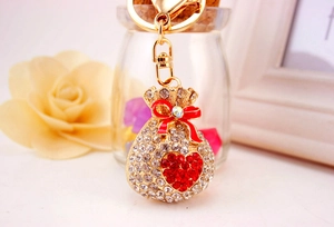 Close-up of sparkling lucky bag keychain with red heart rhinestone and enamel bow