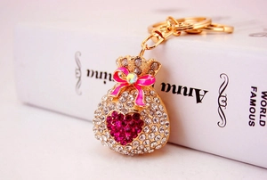 Close-up of sparkling lucky bag keychain with pink crystal heart and bow accents
