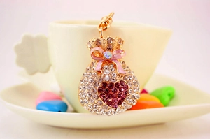 Detail of money bag keychain with white and purple rhinestones and pink bow charm