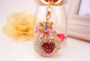 Detail of crystal money bag keychain with pink bow and heart rhinestone for bags