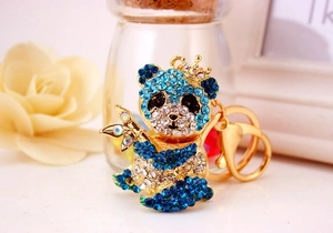 Dettaglio portachiavi a forma di panda con strass blu e trasparenti su metallo dorato