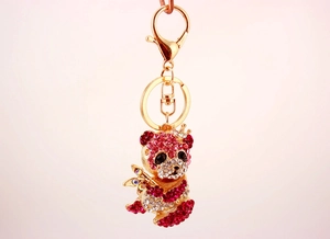 Dettaglio del portachiavi a forma di panda con strass luccicanti, corona dorata e bambù