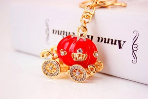 Close-up of red and gold pumpkin carriage keychain with shiny crystal rhinestones