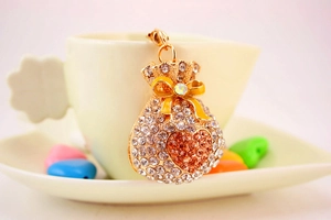 Close-up of golden money bag keychain with crystal rhinestones and heart motif