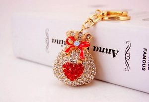 Detail view of gold money bag keychain with white rhinestones and a red heart pattern