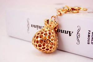 Close-up of a hollow golden fortune bag keychain with sparkling crystal embellishments