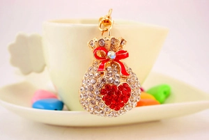 Detail of crystal lucky bag keychain with red heart and bow on a white cup
