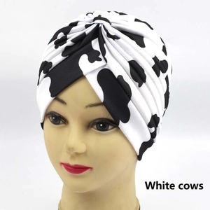 Close-up of black and white cow print turban hat with stylish pleated texture design